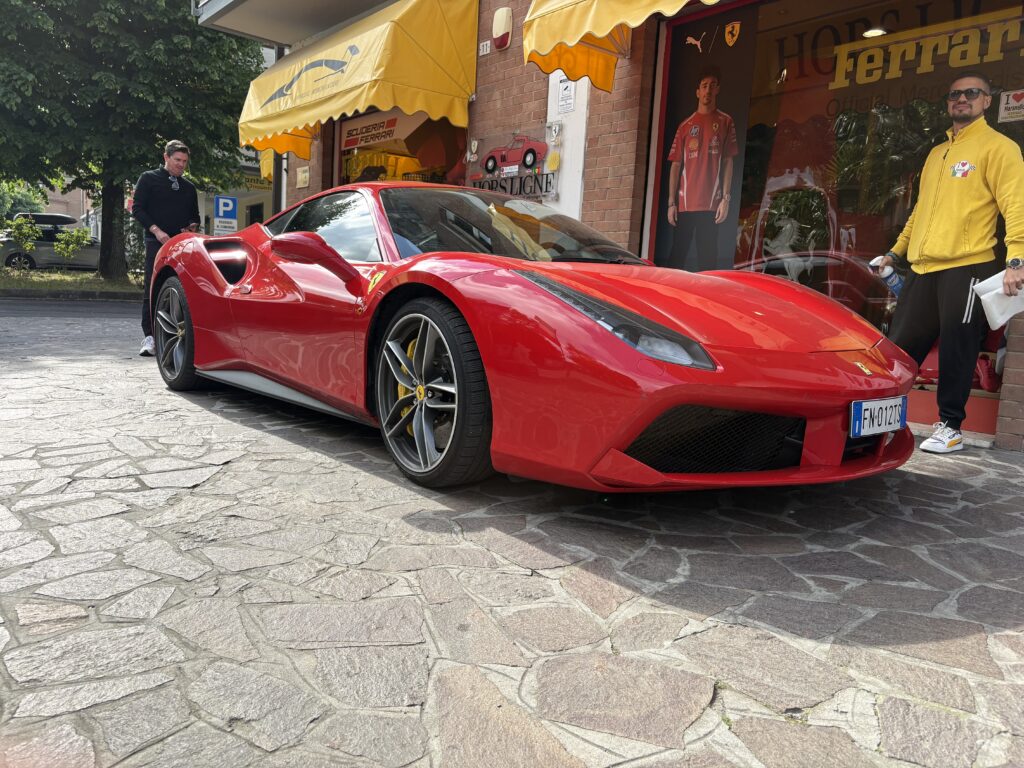 Red Ferrari 488 parked outside a shop in Maranello, Italy